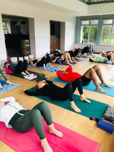 Yoga class taking place in orangery at Plas Cilybebyll